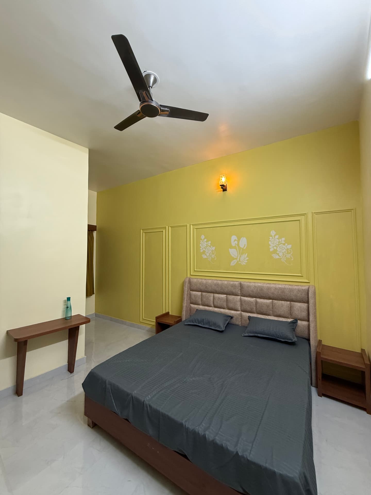 JSR Palace guest room with mustard-yellow accent wall and stencil art, Pushkar